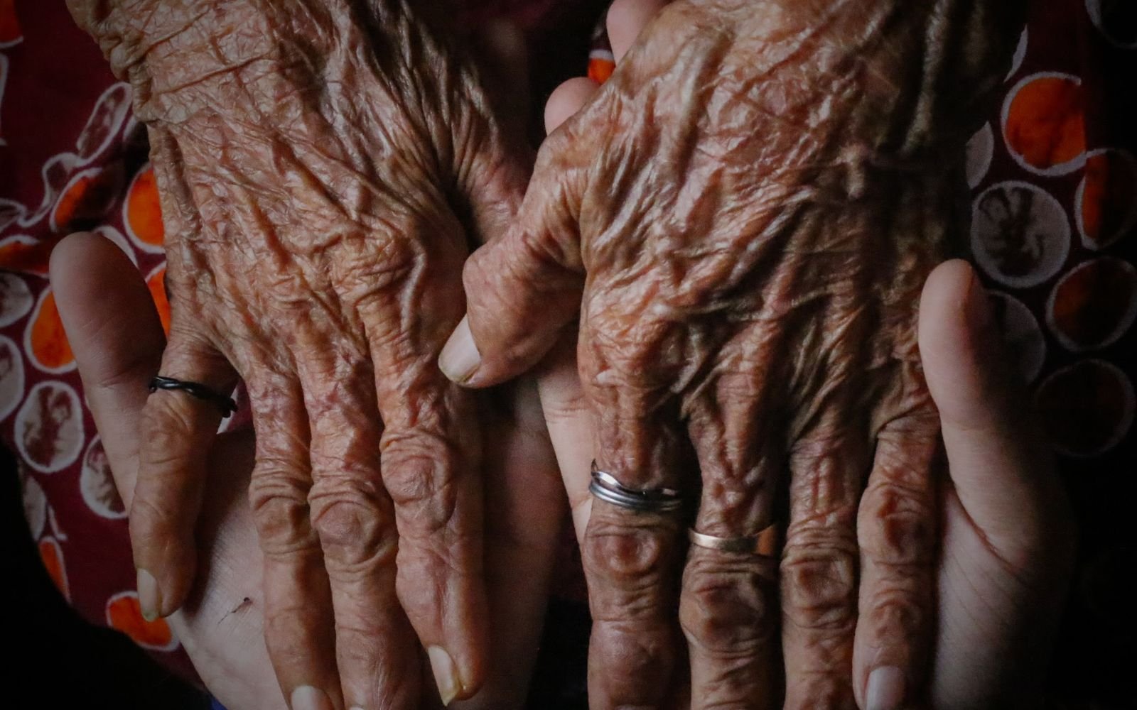 Mains d'une personne âgée tenues par des mains plus jeunes